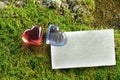 Two transparent glass hearts red and blue on green moss. Tablet for text. Mockup. Valentine`s Day. Royalty Free Stock Photo