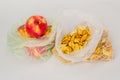 Two transparent plastic crumpled cellophane bags with ripe red apples and yellow dried slices of dry apples on white background. T Royalty Free Stock Photo