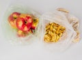 Two transparent plastic crumpled cellophane bags with ripe red apples and yellow dried slices of apples on white background. Top v Royalty Free Stock Photo