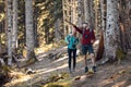 Two travel hikers with backpack walking while man pointing something in the landscape in the forest.