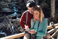 Two travel hikers doing a consultation with your mobile phone on the wood bridge in the forest