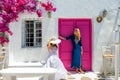 Two traveler woman in front of a traditional cylcadic house on the island of Paros