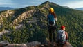 Two travelers on the background of mountains, panorama. Travelers at sunset in the mountains. Tourists with backpacks Royalty Free Stock Photo