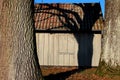 Two trees standing on front of a old wooden shed Royalty Free Stock Photo