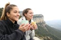 Two trekkers drinking and contemplating in a cliff