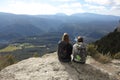 Two trekkers resting contemplating on the top of a cliff