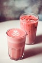 Two trendy beetroot lattes with latte art on table in cafe. Royalty Free Stock Photo