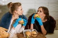 Two trendy women eating burgers Royalty Free Stock Photo