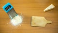 two triangular slices of grana cheese being grated. italian cheese pecorino romano, grana padano and parmesan reggiano.