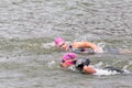 Two triathletes swim on start of the triathlon competition