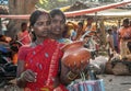 Two Tribal women choosing earthenware in a weekly rural market place.