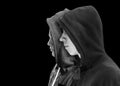 Two troubled teenage boys with black hoodie standing next to each other in profile isolated on black background. Black and white i Royalty Free Stock Photo