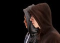 Two troubled teenage boys with black hoodie standing next to each other in profile isolated on black background - stock Royalty Free Stock Photo