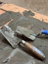 Two trowels on the brickwork of a heating stove base. Royalty Free Stock Photo