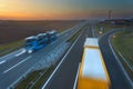 Two trucks in motion blur on the freeway at sunset Royalty Free Stock Photo