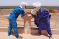 Two Tuaregs in blue dress and white turbans playing game Royalty Free Stock Photo