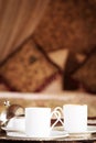 Two turkish coffee cups with oriental canopy bed at the background