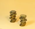 Two turrets made of coins. Scattering of coins on a beige background Royalty Free Stock Photo