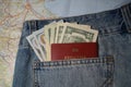 American dollars and foreign passport in the jeans pocket on the tourist map background. Royalty Free Stock Photo