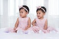 Two twin babies in pink dress on bed Royalty Free Stock Photo