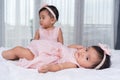 Two twin babies in pink dress on bed Royalty Free Stock Photo
