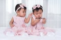 Two twin babies in pink dress on bed Royalty Free Stock Photo