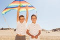 Two twin boys play with kite on the sea beach Royalty Free Stock Photo