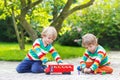 Two twin boys playing with red school bus