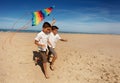 Two twin boys run with kite on the sea beach Royalty Free Stock Photo