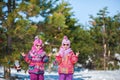 Two twins in the forest on the background of the Christmas tree show rock goat gesture Royalty Free Stock Photo