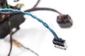 Two twisted blue electrical wires with a black connector closeup on a white background and other cables. Installation and
