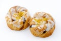 Two twisted lemon and sultana Danish pastries covered with flavoured icing and lemon shred Royalty Free Stock Photo