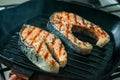 Two two toasted salmon steaks with spices and herbs on a grill p Royalty Free Stock Photo