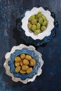 Two types of olives in ceramic plates on a blue background. Healthy natural food. A powerful antioxidant and healthy product. Top