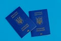 Two Ukrainian passports with a golden trident symbol on a blue blue background. Biomedical Ukraine passport id