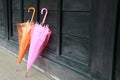 Two umbrellas lean on wood wall Royalty Free Stock Photo