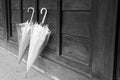 Two umbrellas lean on wood wall