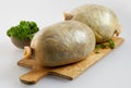 Two uncooked haggis on a chopping board