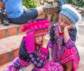 Two unidentified Akha children pose for tourist photos at Wat Phratat Doi Suthep on in Chiang Mai, Thailand.