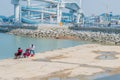 Two unidentified men fishing from concrete pier