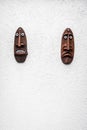 Two unique and cultural African wooden masks with surprised and sad faces attached to the wall Royalty Free Stock Photo