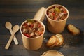 Two unlabelled takeaway tubs of rich beef goulash