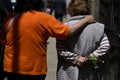 elderly women walk hugging on the street