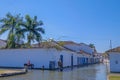 Two unrecognizable kids ride horses through the water of the flooded colonial city of Paraty, Rio de Janeiro, Brazil