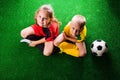 Two unrecognizable little football players against green grass Royalty Free Stock Photo