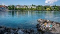 Two unrecognizable young women sun tanning on the shores of Lake Geneva and city view in Ouchy district Lausanne Switzerland Royalty Free Stock Photo