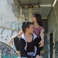 Two urban girls sitting on rusted stairs Royalty Free Stock Photo