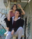 Two urban girls sitting on rusted stairs Royalty Free Stock Photo