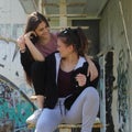 Two urban girls sitting on rusted stairs Royalty Free Stock Photo