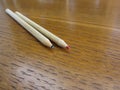 Two used colored pencils on wooden table